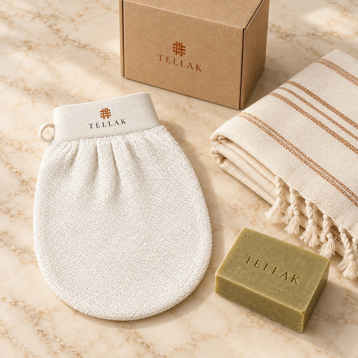 Kese mitt, olive oil soap bar and striped peshtemal towel on cream marble