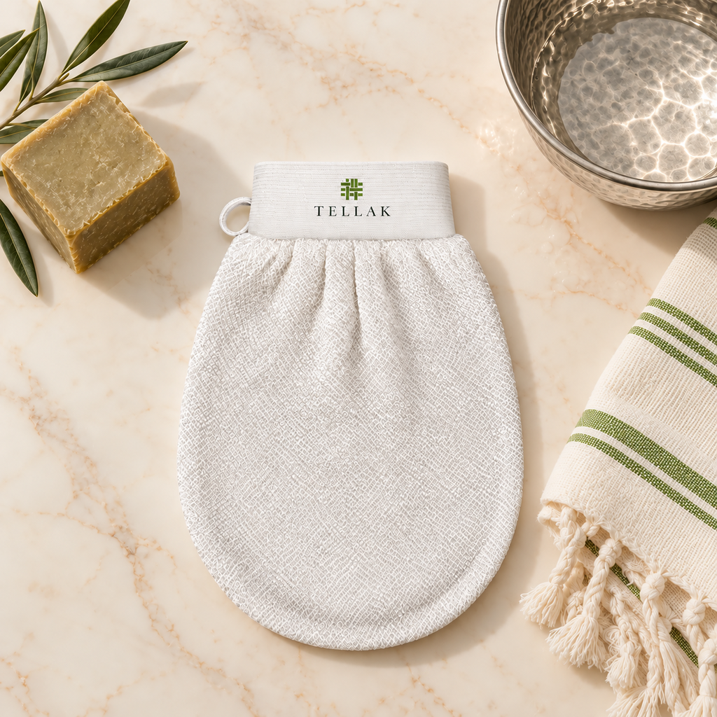 Tellak mitt on marble with olive oil soap, a hammam bowl and an olive-striped peshtemal towel