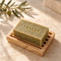 Tellak olive oil soap bar stamped with the Tellak name on a wooden soap dish